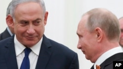 Russian President Vladimir Putin, right, and Israeli Prime Minister Benjamin Netanyahu talk to each other during their meeting in the Kremlin in Moscow, Russia, May 9, 2018.