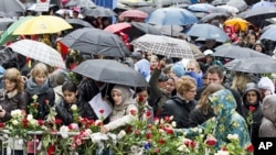 People place flowers near the entrance of a courthouse where the trial of Anders Behring Breivik is conducted, as thousands turn up in poor weather to sing a popular children's song in Oslo April 26, 2012. 