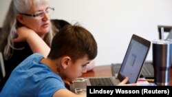 资料照片：华盛顿州伍丁维尔的一名四年级小学生在家通过网络查看老师留给他的作业。(2020年3月11日)