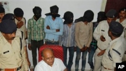 Five men, faces covered, are among the six accused of raping a Swiss tourist in central India, at police control room in Datia, March 17, 2013.