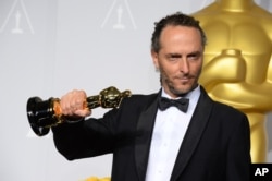FILE - Emmanuel Lubezki poses with the award for best cinematographer of the year for "Gravity" during the Oscars, March 2, 2014.