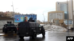 Libyan security forces and emergency services surround Tripoli's central Corinthia Hotel (R) in the Libyan capital, Jan. 27, 2015. 