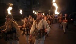 Penari membawa obor saat mereka melakukan ritual kuno mengusir roh jahat di jalan-jalan Batanovci, Bulgaria, Kamis malam, 13 Januari 2022.