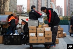 Delivery workers sort parcels for their customers in Beijing, Nov. 11, 2016. In a bright spot for China's cooling economy, online shoppers spent billions of dollars Friday on "Singles Day," a quirky holiday that has grown into the world's busiest day for e-commerce.