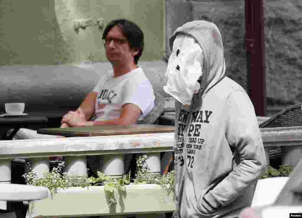 A man uses a plastic bag as a face mask as he walks past a cafe amid the coronavirus disease outbreak in Kyiv, Ukraine.