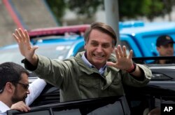 Jair Bolsonaro, presidential candidate with the Social Liberal Party, waves after voting in the presidential runoff election in Rio de Janeiro, Brazil, Oct. 28, 2018.