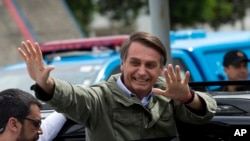 Jair Bolsonaro, presidential candidate with the Social Liberal Party, waves after voting in the presidential runoff election in Rio de Janeiro, Brazil, Sunday, Oct. 28, 2018. Bolsonaro is running against leftist candidate Fernando Haddad of the Workers’ P