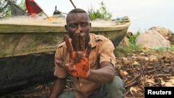 A fisherman shows an oil slick on his palm, by the shore of the Niger Delta region in Brass, Nigeria, Dec. 2, 2013.