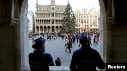 Belgian police officers stand guard on Brussels' Grand Place, December 29, 2015, after two people were arrested in Belgium on Sunday and Monday, both suspected of plotting an attack in Brussels on New Year's Eve, federal prosecutors said. 