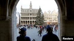 Belgian police officers stand guard on Brussels' Grand Place, December 29, 2015, after two people were arrested in Belgium on Sunday and Monday, both suspected of plotting an attack in Brussels on New Year's Eve, federal prosecutors said. 
