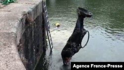 FILE - In this screen grab taken from video released by Bristol City council June 11, 2020, the toppled statue of Edward Colston is seen being retrieved from the harbor in Bristol, southwest England.