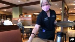 Tricia Erback menyajikam sarapan di Fryn' Pan Family Restaurant di Fargo, North Dakota, di tengah pandemi virus corona, 1 Mei 2020. (Foto: AP)