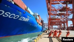 19일 중국 산둥성 칭다오 항에서 인부들이 중국 국영선사인 COSCO(China Ocean Shipping Company) 선박을 부두에 대는 작업을 하고 있다. (자료사진) 