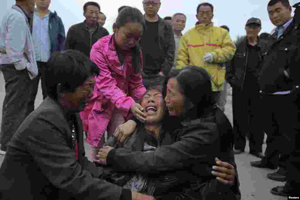 People cry after their relative died in a fire at a poultry slaughterhouse in Dehui, Jilin province, China.