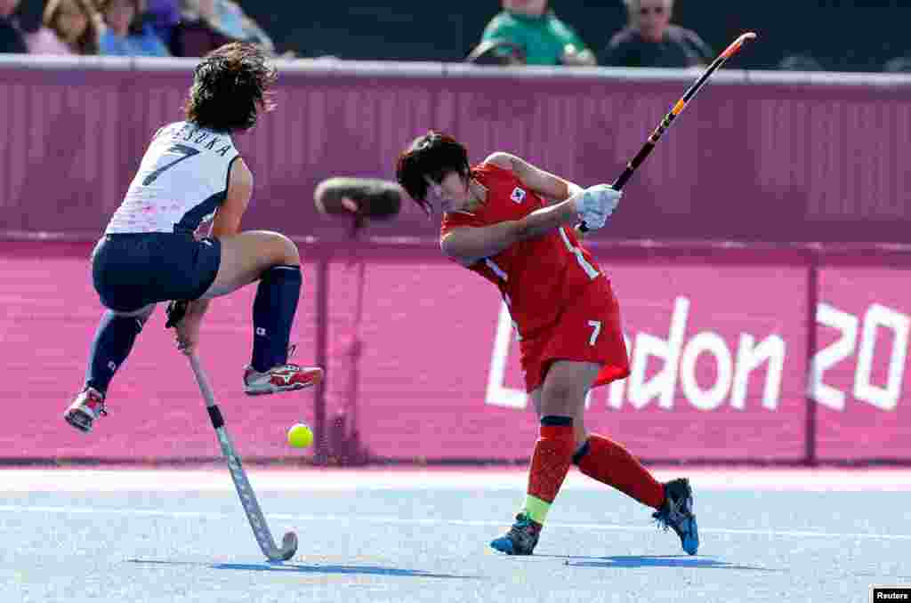 Japan's Shiho Otsuka (L) challenges South Korea's Lee Seonok in their women's Group A hockey match.