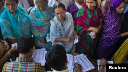 12일 인도 북부 바라나시 투표소에서 유권자들이 선거인명부의 이름을 확인하고 있다. 