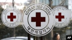 A pedestrian moves past the logos of the Korea Red Cross at its headquarters in Seoul, South Korea, Wednesday, Feb. 9, 2011. South Korea agreed Wednesday to hold talks with North Korea on reuniting families separated by war, as military officers from both