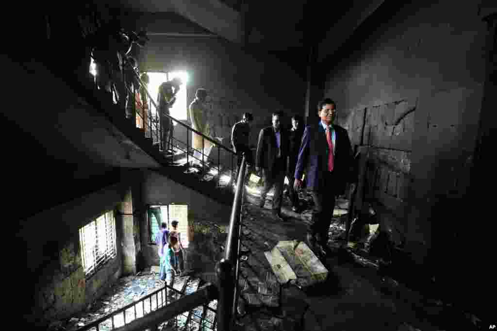Bangladeshi officials inspect a garment-factory where a fire killed more than 110 people Saturday on the outskirts of Dhaka, Bangladesh, November 26, 2012. 