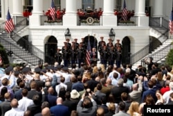 U.S. President Donald Trump holds his hand over his heart and sings the U.S. National Anthem along with members of the United States Army Chorus at the "celebration of the American flag" event on the South Lawn of the White House in Washington, June 5, 2018.