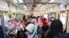 Para penumpang perempuan mengenakan masker di gerbong kereta commuter, di Jakarta, di tengah wabah COVID-19, 7 April 2020. (Foto: AFP)