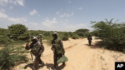 Ugandan peacekeepers from the African Union Mission in Somalia (AMISOM) patrol a road following an encounter with Islamist militia in the northern suburbs of Somalia's capital Mogadishu, January 20, 2012.