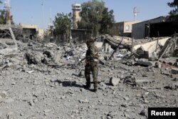File - a policeman walks past the rubble of a building destroyed by saudi-led airstrikes at sanaa airport in sanaa, yemen, december 21, 2021.
