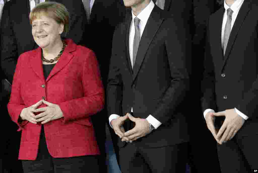 Chancellor Angela Merkel, left, and team members pose for the media during a reception for the German National Handball team at the chancellery in Berlin, Germany.