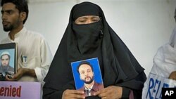 Pakistani Shansum Nasa holds a photo of her son, Atiq ur Rehman, who disappeared in 2004, during a demonstration outside the International Committee of the Red Cross in Islamabad, Pakistan, Jul 23, 2008 (file photo)