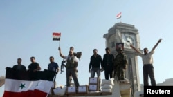 2013年6月5日效忠叙利亚总统阿萨德的政府军和居民占领了反政府战略城镇古赛尔之后高举叙利亚国旗。