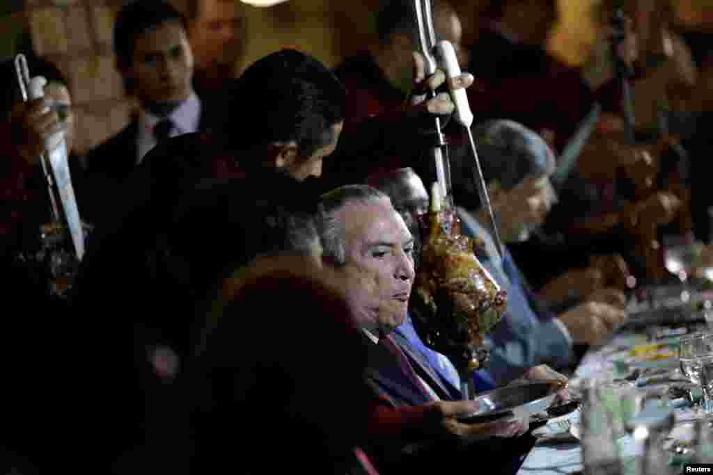 Brazil&#39;s President Michel Temer eats barbecue in a steak house after a meeting with ambassadors of meat importing countries of Brazil, in Brasilia, March 19, 2017.