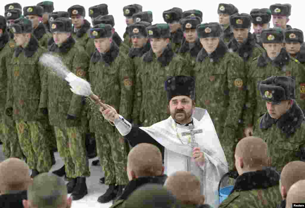 Беларусь. Священник благословляет военнослужащих специального подразделения белорусского МВД во время рождественской службы на военной базе в Минске