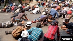 မတ်လ ၃ ရက်နေ့ မန္တလေးမြို့ ဆန္ဒပြပွဲအတွင်း ရဲများက သေနတ်ပစ်ဖောက်တာကြောင့် အကာအကွယ်ယူနေကြတဲ့ ဆန္ဒပြသူများ။ (မတ် ၃၊ ၂၀၂၁)