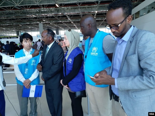 An official from Somalia’s foreign ministry talks to reporters after receiving Somali migrants from Libya in Mogadishu, Feb. 17, 2018. (H.K. Qoyste/VOA)