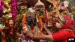 امرتسر کے مندر میں ایک عقیدت مند ہندو کالی دیوی کی مورتی کو مالا چڑھا رہی ہیں۔(فائل فوٹو: اے ایف پی)