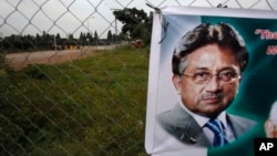 FILE - A poster of former Pakistani President Pervez Musharraf is seen hung up near a checkpoint outside his house, where he has been held under house arrest in Islamabad, Pakistan, Wednesday, Nov. 6, 2013.