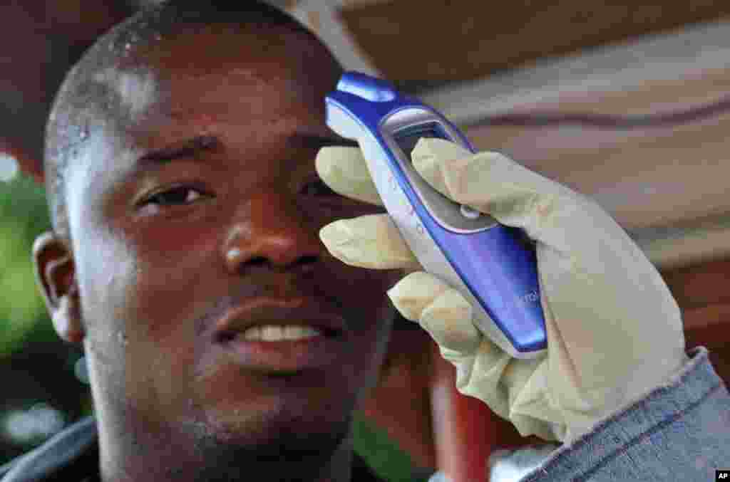 Một người đàn ông đang&nbsp;được đo nhiệt độ trước khi đi vào một trung tâm thương mại vì nỗi lo sợ dịch bệnh Ebola chết người lan tràn khắp thành phố Monrovia, Liberia, ngày 9/8/2014. &nbsp;
