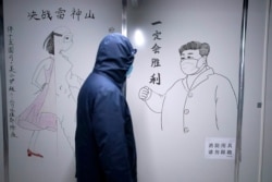 一名男子走過武漢疫情期間的一幅宣傳習近平的畫像