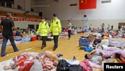 因台风烟花的侵袭，工人们从临港新区疏散撤离到上海的一个体育馆里。（2021年7月25日）