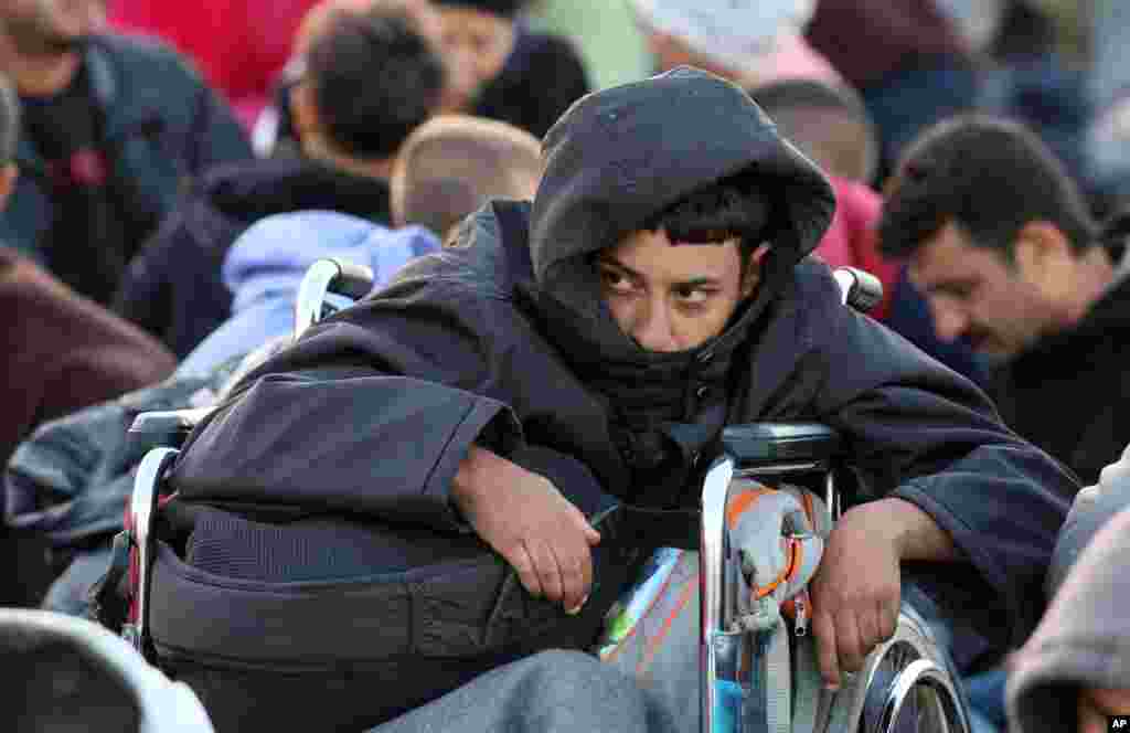 A migrant waits in a wheelchair after crossing the border between Hungary and Austria in Nickelsdorf, Austria, 70 kilometers (43 miles) southeast of Vienna, Sept. 20, 2015.