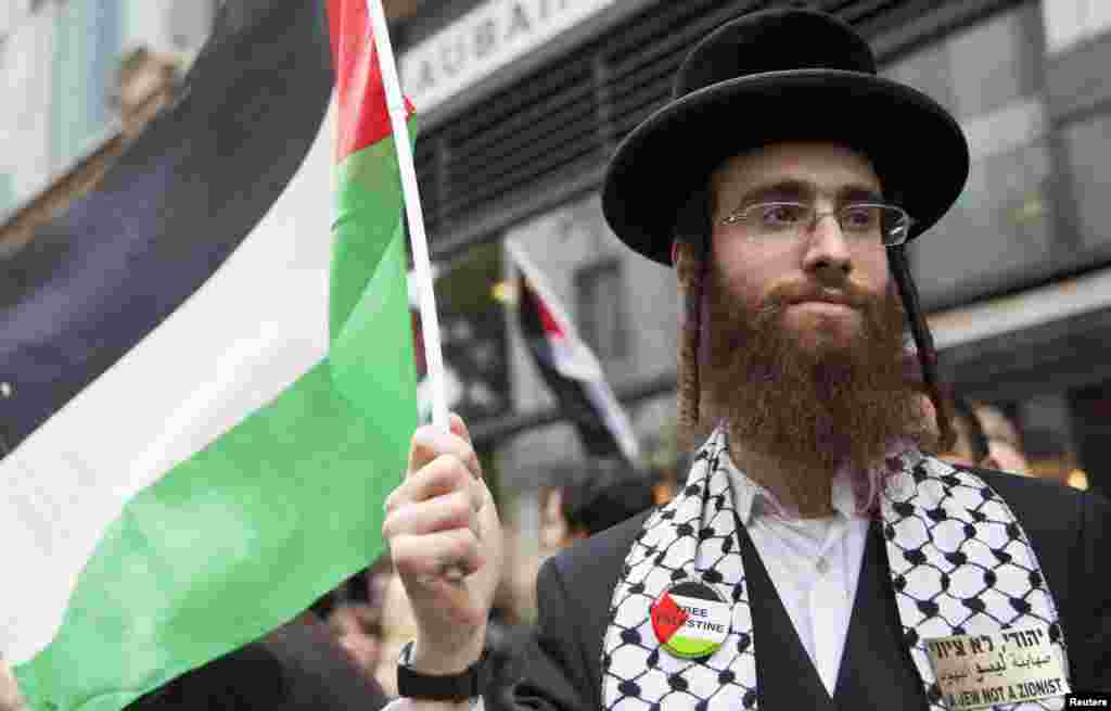 An ultra-Orthodox Jew holds a Palestinian flag during a protest against Israeli air strikes on Gaza, London, July 11, 2014.