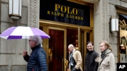 FILE - People pass the Polo Ralph Lauren store on Fifth Avenue in New York, April 4, 2017.