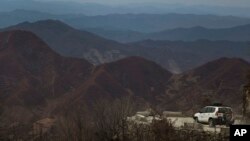 FILE - In this Nov. 6, 2013 photo, a World Food Program vehicle drives on a mountain road near the city of Kimchaek, in northeastern North Korea.