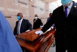 In this April 22, 2020, file photo, pallbearers, who were among only 10 allowed mourners, walk the casket for internment at the funeral for Larry Hammond, who died from the coronavirus, at Mount Olivet Cemetery in New Orleans.(AP Photo/Gerald Herbert, File)