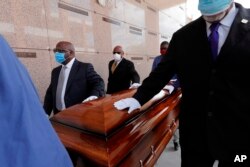 In this April 22, 2020, file photo, pallbearers, who were among only 10 allowed mourners, walk the casket for internment at the funeral for Larry Hammond, who died from the coronavirus, at Mount Olivet Cemetery in New Orleans.(AP Photo/Gerald Herbert, File)