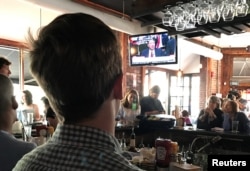 People gather to watch former FBI director James Comey testify before the Senate Intelligence committee in Shaw's Tavern in Washington, June 8, 2017.