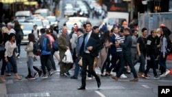 FILE - Pedestrians cross a road in Sydney, Australia, Sept. 6, 2017. Australia's population has reached 25 million for the first time, according to official estimates. 