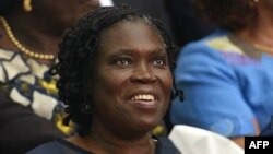 Simone Gbagbo, Ivory Coast's former first lady, smiles as she sits in the dock at the Court of Justice in Abidjan on Dec. 26, 2014 for the start of her trial.