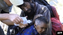 An American nurse from the Save the Children non-governmental organization treats a Pakistani baby injured in the earthquake in Pashto area in the mountains in the north of the country. (File Photo) 
