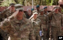 FILE - U.S. soldiers salute at Resolute Support headquarters in Kabul, Afghanistan, July 15, 2017.