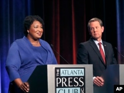 FILE - In this Tuesday, Oct. 23, 2018 file photo, Democratic gubernatorial candidate for Georgia Stacey Abrams, left, speaks as her Republican opponent Secretary of State Brian Kemp looks on during a debate in Atlanta.